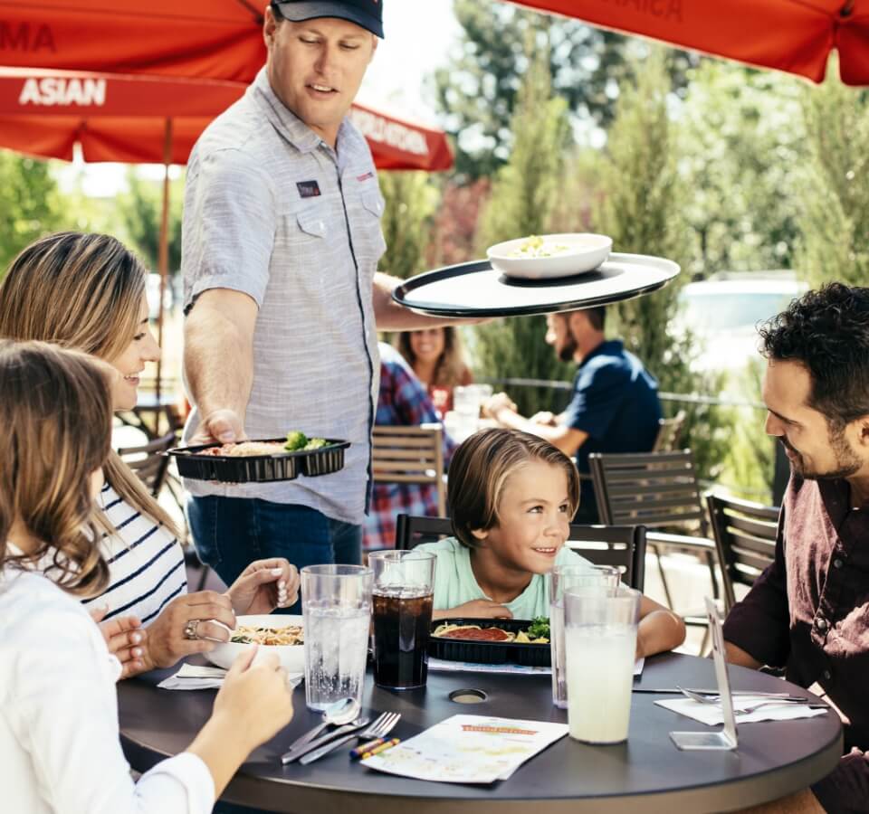 noodles server serving food to a happy family